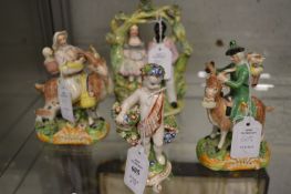 A pair of 19th century pottery figures on goats together with a pottery figure of a cherub and a