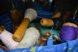 A quantity of large turned bobbin reels with cotton.