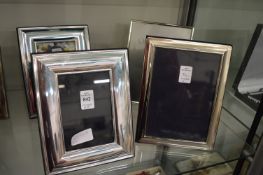 Four silver plated photograph frames.