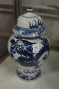 A pair of Chinese baluster shaped vases and covers painted with dragons.