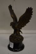 A cast bronze figure of a eagle with wings out swept.