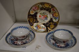 A pair of 19th century cups and saucers and a floral decorated saucer.