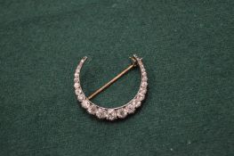 A Victorian diamond set crescent shaped brooch.