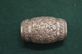 An Eastern white metal barrel shaped double ended pepperette with engraved decoration.