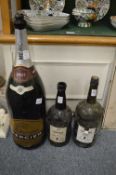 Two large Sandeman port bottles and a large Champagne bottle.