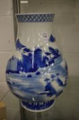 A large Chinese blue and white vase painted with a landscape.