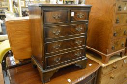 A small reproduction mahogany chest of drawers.