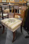 A set of six 19th century mahogany dining chairs with needlework upholstered seats, supported on
