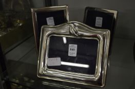 Three modern silver photograph frames.