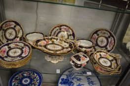 A 19th century porcelain part dinner service, gilt and blue decorated, painted with panels of