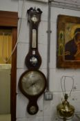 A mahogany cased wheel barometer/thermometer.