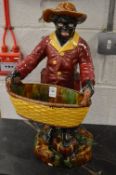 A majolica jardiniere modelled as a man holding a basket.