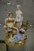 A 19th century porcelain figure group of children by a statue.
