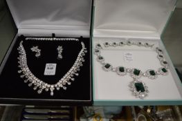 Two decorative necklaces, one with matching earrings.