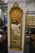 A decorative gilt framed narrow mirror.