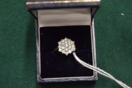 A gold and diamond cluster ring.