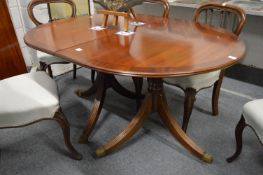 A good quality reproduction mahogany twin pedestal extending dining table with one leaf.