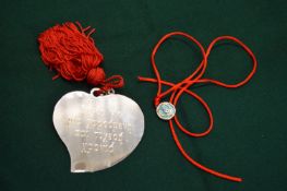 A silver heart shaped pendant.
