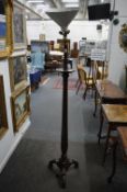 A carved mahogany torchiere style floor standing lamp.