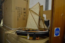 A model sailing ship and two garden ornaments.