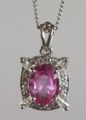 AN 18CT WHITE GOLD, PINK SAPPHIRE AND DIAMOND PENDANT and 18ins white gold chain.