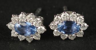 A PAIR OF 18CT WHITE GOLD OVAL SAPPHIRE AND RBC DIAMOND CLUSTER STUDS, boxed. Sapphires 0.66ct.