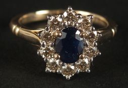 A 9CT YELLOW GOLD RING set with oval sapphire and a halo of RBC diamonds, boxed. Sapphire 1.00ct