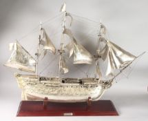 A LARGE .925 SILVER MODEL OF H.M.S. VICTORY 1765, on a stand. 30ins high x 40ins long.
