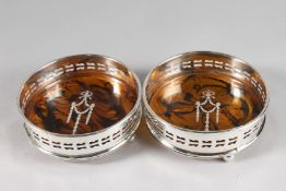 A PAIR OF PIERCED SIDE CIRCULAR WINE COASTERS with faux tortoiseshell bases.