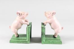 A PAIR OF PAINTED CAST IRON PIGS. 5.5ins high.