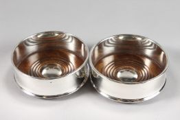 A PAIR OF PLAIN PLATE CIRCULAR WINE COASTERS with turned wood bases.