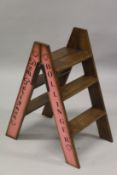 A SET OF DOM PERIGNON, BOLLINGER, MOET AND VEUVE PAINTED WOODEN FOLDING LADDERS.