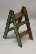 A SET OF DOM PERIGNON, BOLLINGER, MOET AND VEUVE PAINTED WOODEN FOLDING LADDERS.