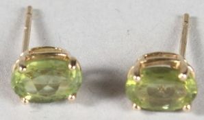 A PAIR OF 9CT GOLD PERIDOT STUD EARRINGS.