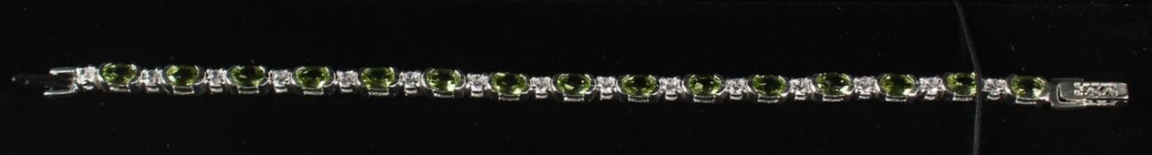 A SILVER PERIDOT LINE BRACELET.