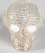 A SILVER OPAL EYE SKULL HEAD RING.
