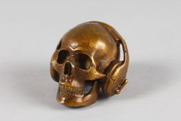 A SMALL BRONZE SKULL with headphones. 2.5ins.