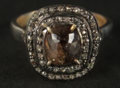 A SILVER GILT DRESS RING set with a central fancy brown rose-cut cushion-shaped diamond and two