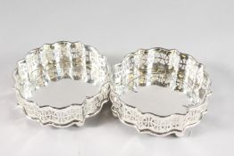 A PAIR OF PIERCED SIDE CIRCULAR WINE COASTERS with faux tortoiseshell bases.