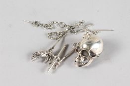 A SILVER SKULL ON A CHAIN.