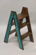 A SET OF DOM PERIGNON, BOLLINGER, MOET AND VEUVE PAINTED WOODEN FOLDING LADDERS.