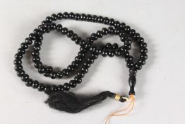 A GOOD SMALL JADE BEAD NECKLACE with tassel. 24ins long.