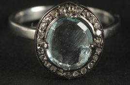 A RING SET WITH AN OVAL CHECKERBOARD CUT AQUAMARINE AND A HALO OF DIAMOND in silver. Aquamarine 1.