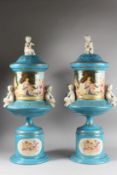 A LARGE PAIR OF SEVRES DESIGN BLUE GROUND PORCELAIN VASES AND STANDS with cupid handles. 30ins