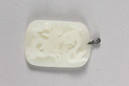 A CHINESE CARVED WHITE JADE PENDANT with silver top. 2ins x 1.5ins.