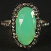 A DRESS RING set with a central chrysoprase and rose-cut diamonds in silver gilt. Oval cabochon