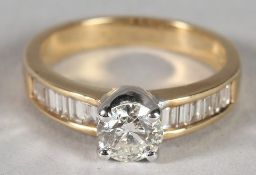 AN 18CT YELLOW GOLD SINGLE STONE DIAMOND RING, certificated 0.73, with baguette diamonds to the