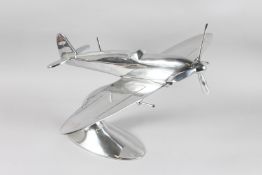 A LARGE CHROME SPITFIRE on an oval base. 20ins long x 17ins high.