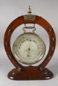 A GOOD HORSESHOE SHAPED FRAME holding a barometer by Hall & Co, Manchester. 18ins high.
