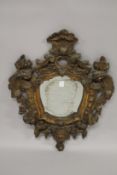 A GOOD SMALL EARLY 18TH CENTURY CARVED AND GILDED WOOD SHAPED MIRROR, carved with nests, flowers,